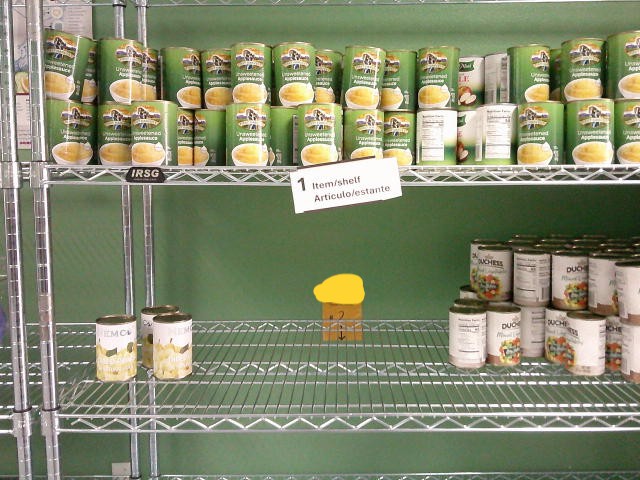 Canned apple sauce on the top shelf and canned pear plus canned mixed vegetables on the middle shelf..